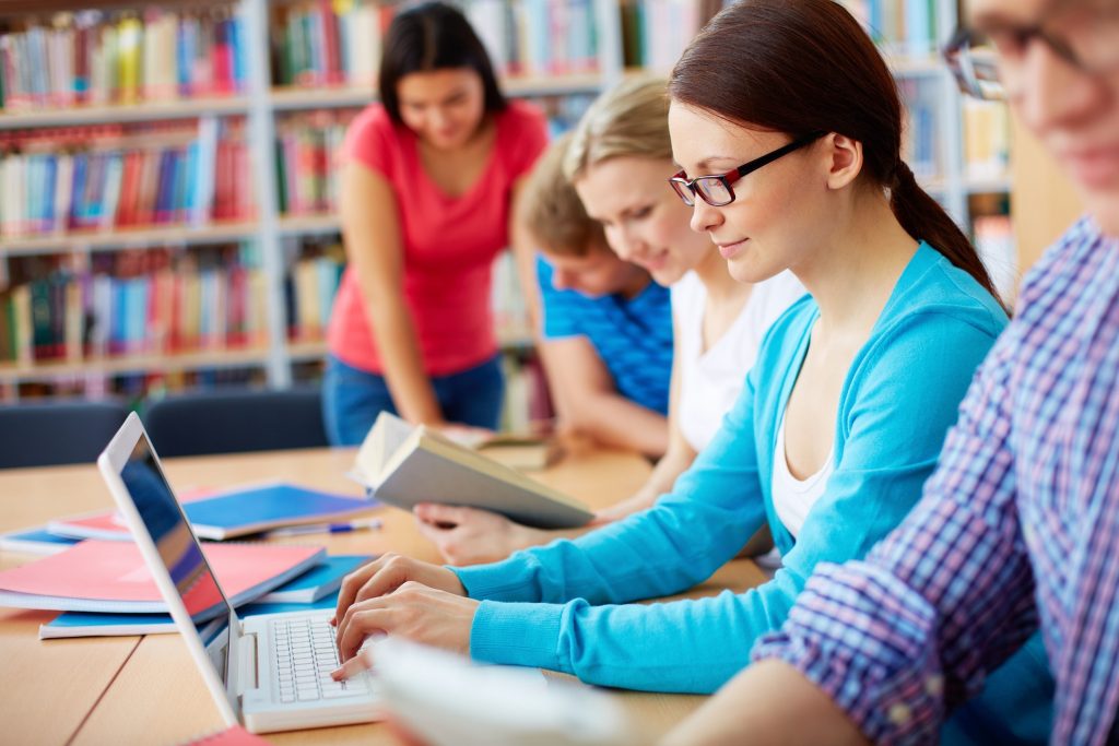 Girl Grinning while Using Laptop
