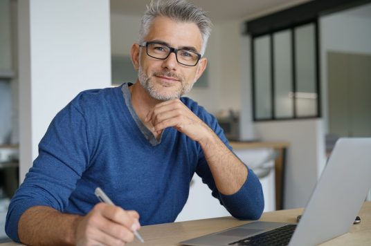 man using computer wearing blu man using computer wearing blu